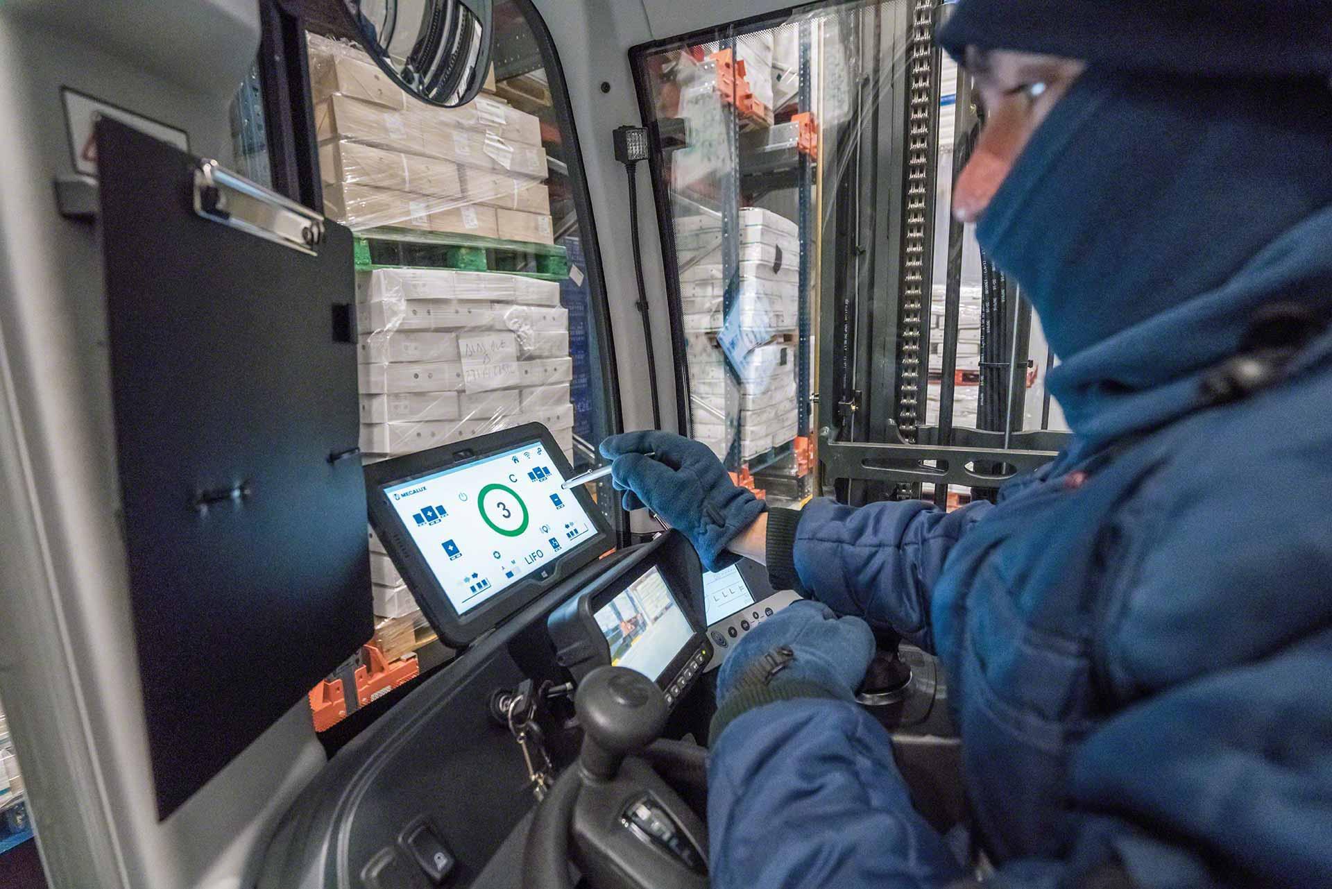 Ein Bediener verwendet ein Tablet in einem Kühlhaus. Ein Bediener verwendet ein Tablet in einem Kühlhaus.