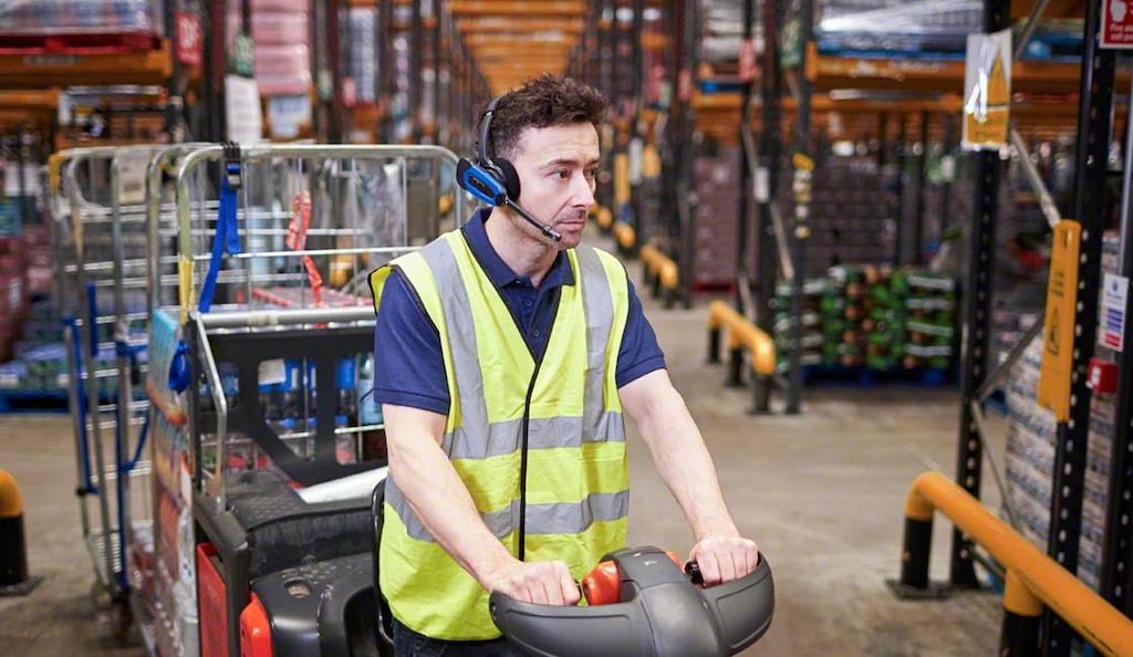 Ein Kommissionierer kann Systeme zur Unterstützung der Kommissionierung, wie Voice-Picking, nutzen