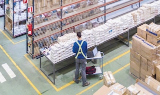 Das Personal des Logistikunternehmens überprüft die Produkte im Lager mit Hilfe eines elektronischen Hilfsgeräts.