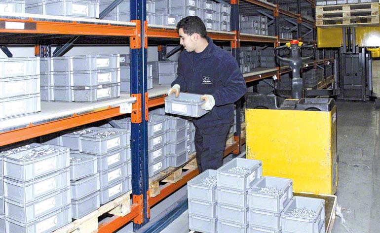 Lagerarbeiter, der direkt von einer Palette kommissioniert.