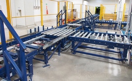 Die Zugänge der palettierten Ware aus der Produktion erfolgen über den Hauptkreislauf der Fördergeräte mit Verbindung zu den Lagergängen über einen Verfahrwagen