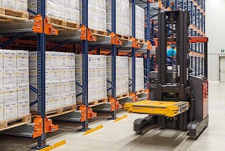 Der Lagermitarbeiter nimmt das Shuttle mit dem Gabelstapler auf und bringt es dann zum Kanal